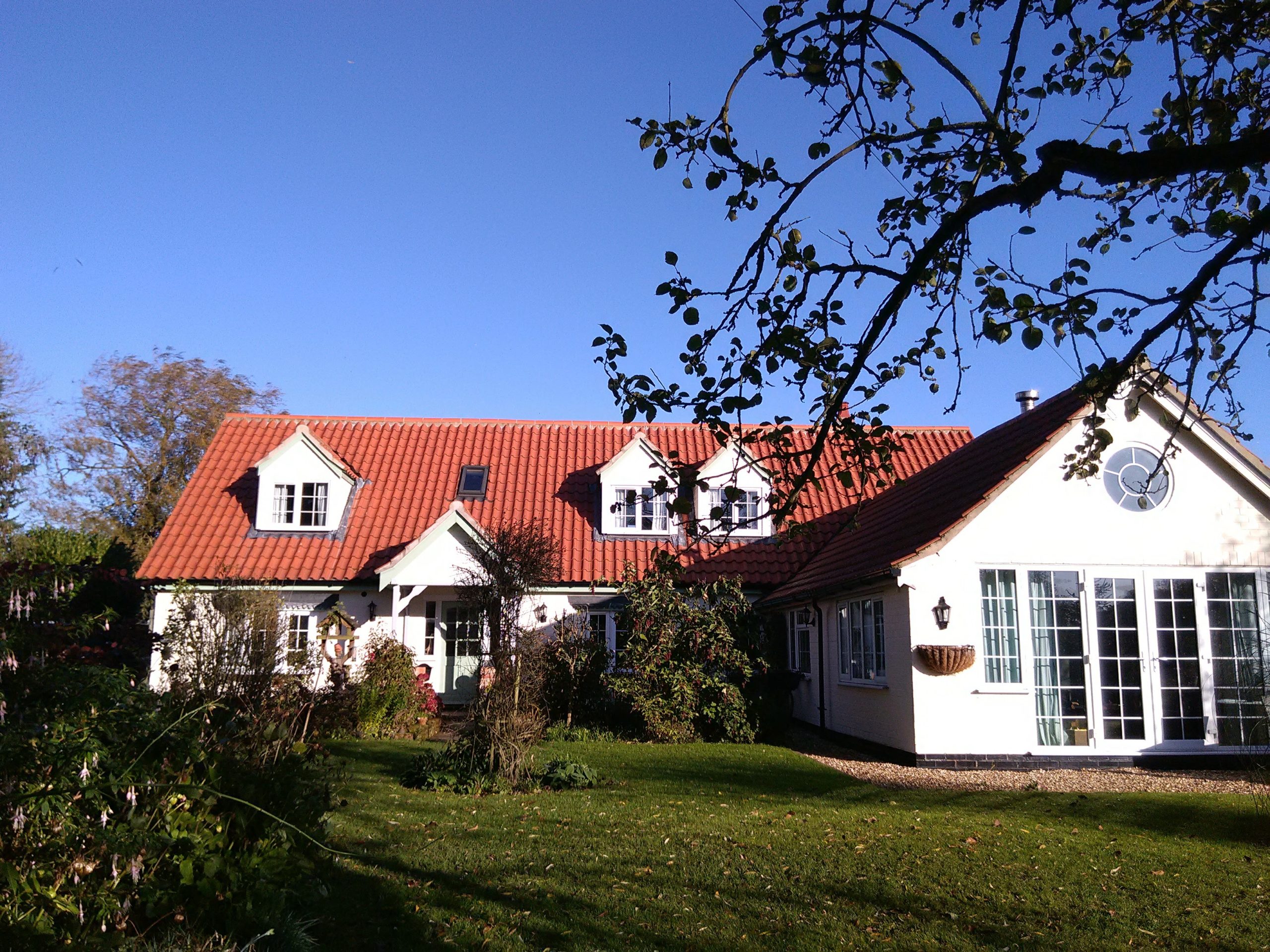 White Cottage Bed and Breakfast from outside on a bright autumn day.